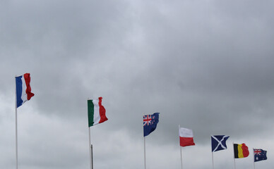 The French, Italian, New Zealand, Polish, Scottish, Belgian and Australian flags on a cloudy sky.