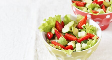 salad with strawberries, avocado, lettuce, green peas.