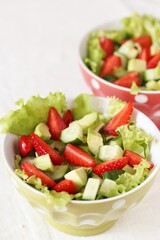 salad with strawberries, avocado, lettuce, green peas.