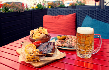 Beer and savory food on table, toned