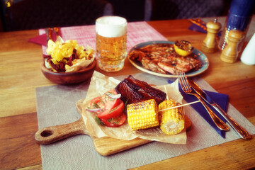 Grilled meat, corn, potato chips and beer, toned