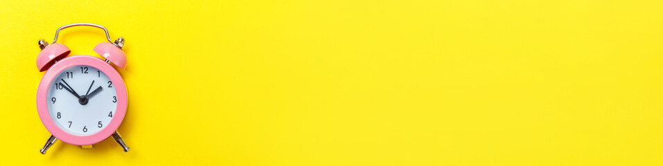 Simply minimal design ringing twin bell classic alarm clock Isolated on yellow background. Rest...