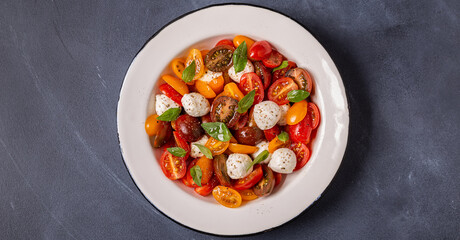 Traditional Caprese salad made of sliced fresh tomatoes, mozzarella cheese and basil