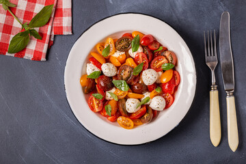 Traditional Caprese salad made of sliced fresh tomatoes, mozzarella cheese and basil