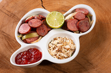 .Pepperoni sausage with onion. Very common appetizers in bars. Accompanied by farofa, pepper jelly. and lime.