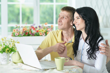 Portrait of happy young couple with laptop