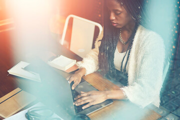 Cropped image of concentrated afro american copywriter working remote in coffee shop and...