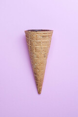 Brown waffle horn filled with cottage cheese in chocolate glaze in the center on pink background, flat lay. Refreshing waffle dessert, idea concept, top view, close up, copy space