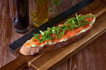Bread toast with salted salmon, pesto sauce and cream cheese ricotta. Gourmet snack. selective focus