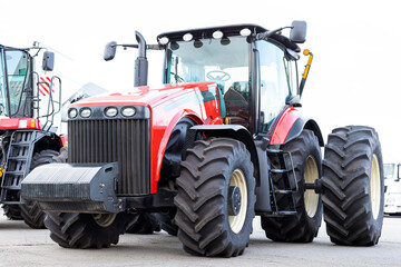 Large agricultural tractor on a white background. Equipment for cultivating the land. Side view. Close-up.