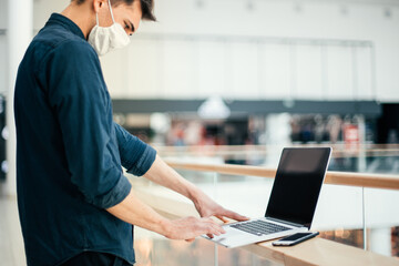 close up. a young man in a protective mask using a laptop