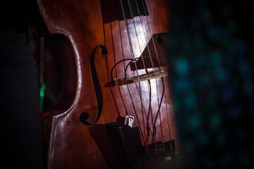 Double-bass fragment in jazz concert stage in background