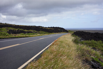Fototapeta premium Chain of Craters Road in Hawaii Volcanoes Nation Park with the Pacific Ocean in the near distance as the sky gradually clears up.