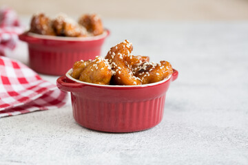 Teriyaki chicken with sesame seeds on a light background.
