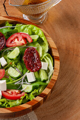 .Green salad with lettuce, arugula, cucumber, cheese and sun-dried tomatoes.
