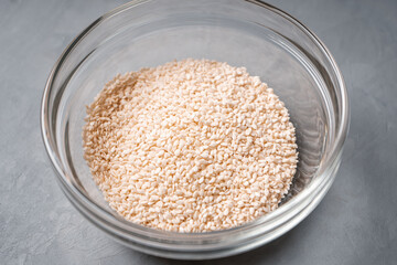 Sesame seeds in a glass plate on a concrete table close-up