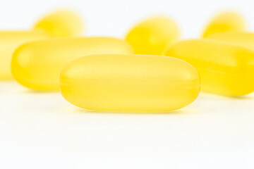 Macro shot of yellow gelatin capsules, isolated on a white background.