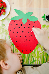 Child draws a strawberry. Exercises for hand training. Early preschool education.
