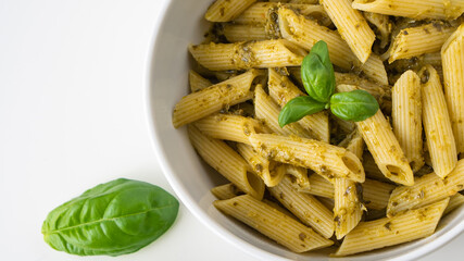 Homemade italian penne pasta noodle cook food with organic green fresh basil leaf cheese nut pesto sauce healthy meal for vegan vegetarian