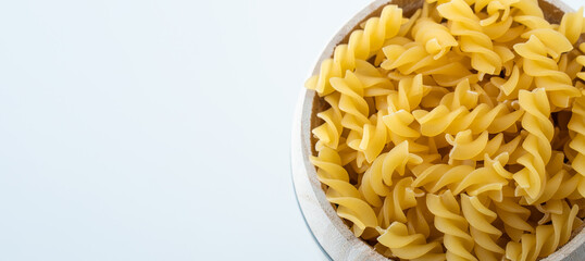 Raw dry uncooked Fusilli pasta spaghetti noodle on white background Good for basil tomato pesto sauce Homemade fresh Italian food organic whole wheat vegan spaghetti noodle for a healthy meal