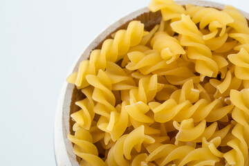 Raw dry uncooked Fusilli pasta spaghetti noodle on white background Good for basil tomato pesto sauce Homemade fresh Italian food organic whole wheat vegan spaghetti noodle for a healthy meal