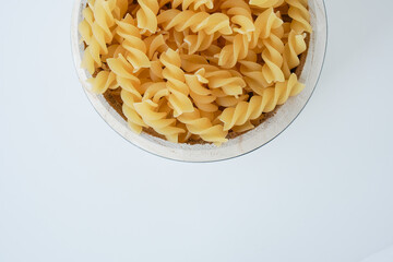 Raw dry uncooked Fusilli pasta spaghetti noodle on white background Good for basil tomato pesto sauce Homemade fresh Italian food organic whole wheat vegan spaghetti noodle for a healthy meal