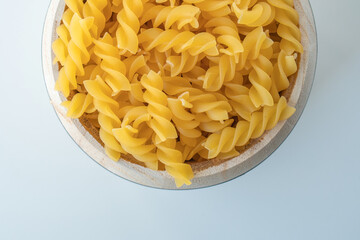 Raw dry uncooked Fusilli pasta spaghetti noodle on white background Good for basil tomato pesto sauce Homemade fresh Italian food organic whole wheat vegan spaghetti noodle for a healthy meal