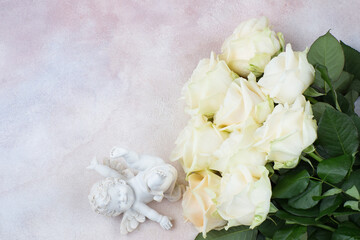Obraz na płótnie Canvas a bouquet of white roses and a white angel figurine