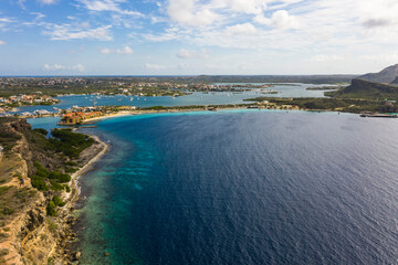 Fototapeta na wymiar Aerial view of coast of Curaçao in the Caribbean Sea with turquoise water, cliff, beach and beautiful coral reef over Caracas Bay