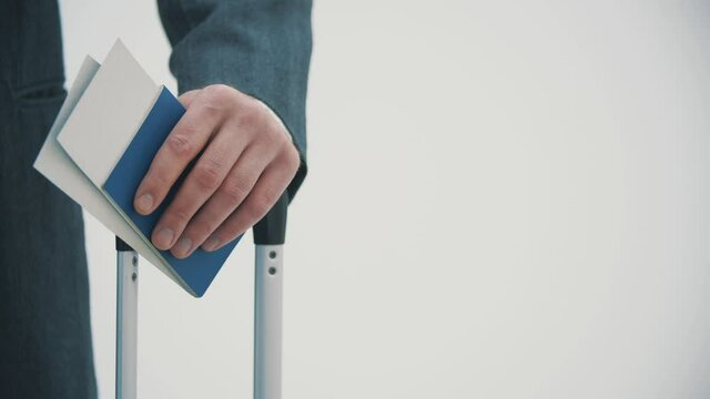 Cropped shot of businessman holding a suitcase and travel documents waiting for the check-in.