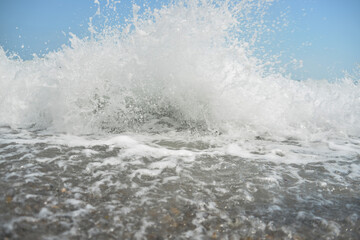 during the day the sea waves and splashes of small drops fall on the shore