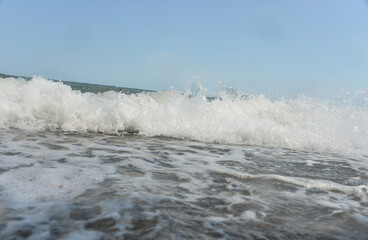 during the day the sea waves and splashes of small drops fall on the shore