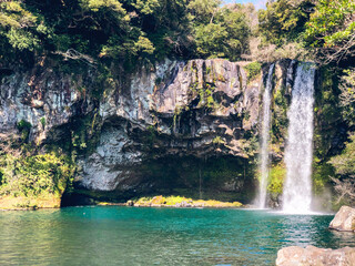 Fototapeta na wymiar The high waterfall and the mountain lake in Jeju island. South Korea