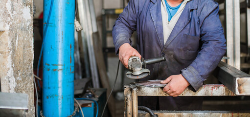 Welder in a work coat. Industrial automotive part in factory Welder at work welding splatter