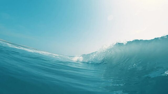 Slow Motion Barrel Wave Breaking on Beach Seashore with Crystal Clear Blue Water on Bright Sunny Day in Ocean Surf