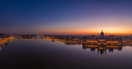 Panoramic aerial drone shot of Hungarian Parliament lights off sunrise in Budapest dawn