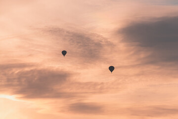 Two balloons on a background of pink sunset and clouds