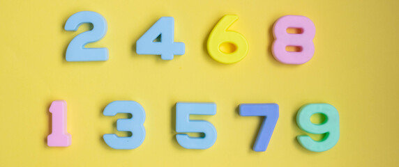 Multi-colored numbers on a yellow background top view. Child Development Concept