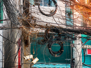 messy chaos wires cables , telephone and internet fiber signal line on electric poles.