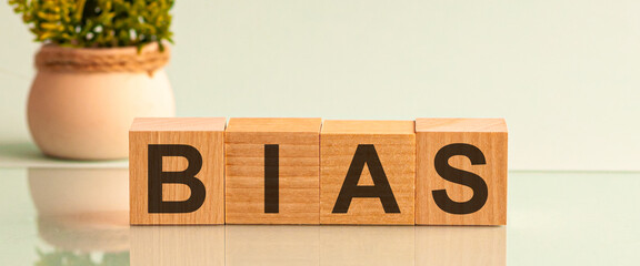 The word BIAS message word on a wooden desk on cube blocks with a flower on background