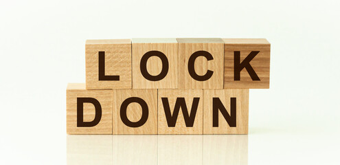 wooden cube blocks with word Lockdown, white glossy background with reflection