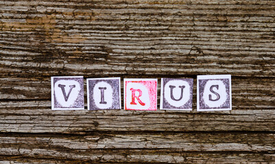 Virus text, ink stamp paper, wooden background.