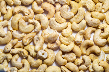 Scattered cashew nuts on a white background.