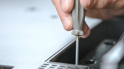 aged man unscrews black television back cover detail repairing set at home closeup