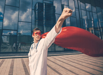confident doctor in a superhero Cape is ready for feats.