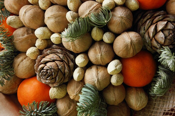 Gift Christmas bouquet. Pine cones, oranges, peanuts, walnuts, spruce branch in a beautiful package. Electoral focus. Christmas and New Year is theme. Holiday theme. Background. Food