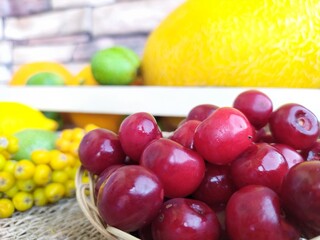 Fruit and berry still life yellow oval melon orange lemon red apple green unripe walnuts and yellow rowan in a wooden box on the kitchen table