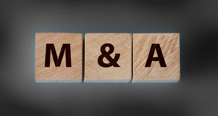 M and A Merger and Acquisition text on wooden cubes. Business ownership concept