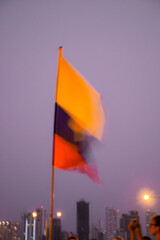 A Colombian flag dances out of focus atop Cafe Del Mar in Cartagena - obrazy, fototapety, plakaty