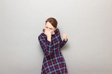 Portrait of angry young woman raising fist up in threatening gesture